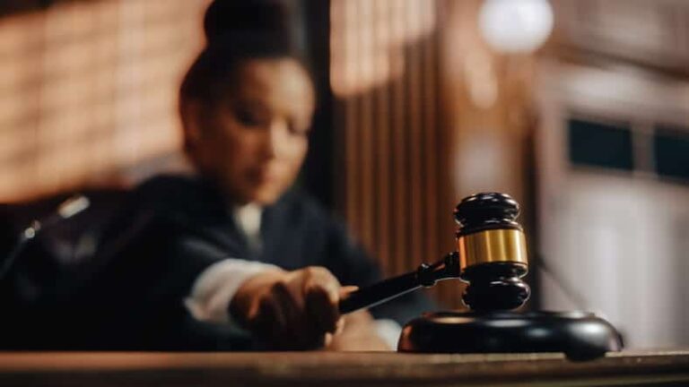 A judge using a gavel while in a courtroom.