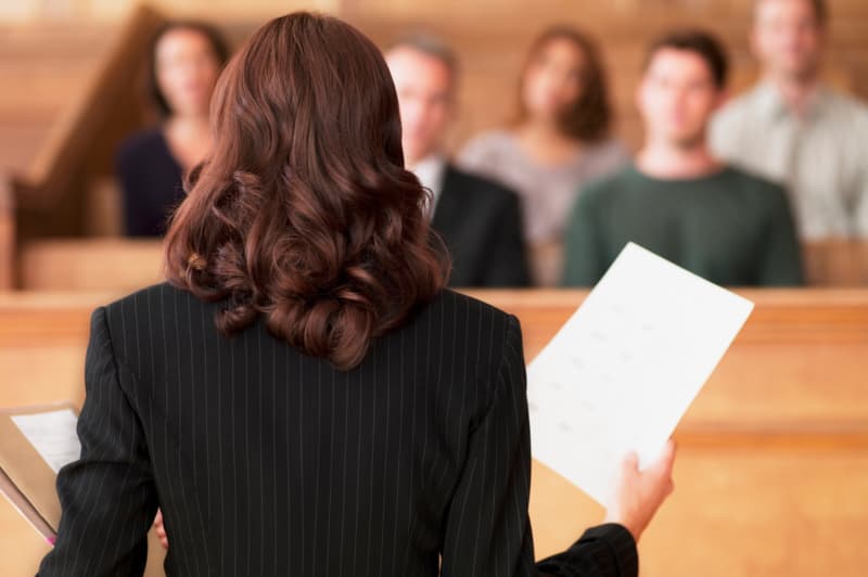 The back of a lawyer standing in front of a courtroom, presenting a wrongful death case.
