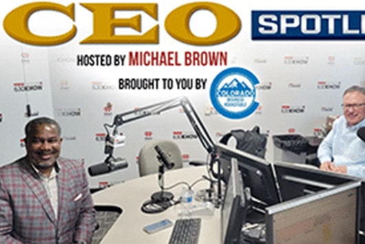 A photo of two men doing a podcast. The text over the picture says, "CEO Spotlight. Hosted by Michael Brown."