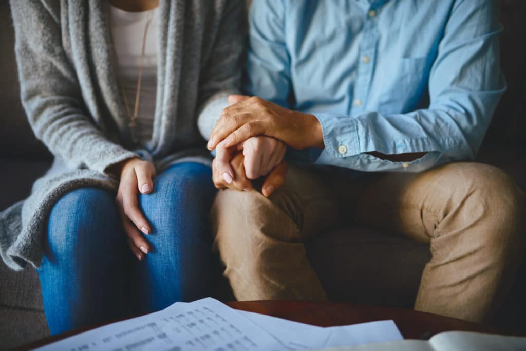 mourning-couple-holding-hands