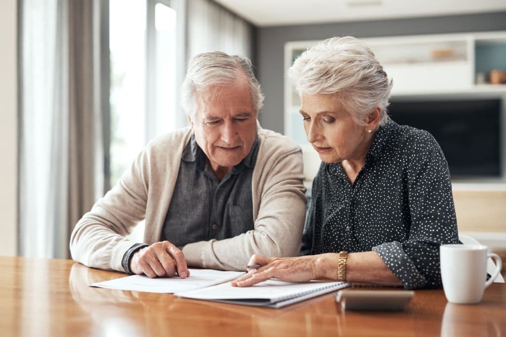 man and woman reading documents that are on a desk