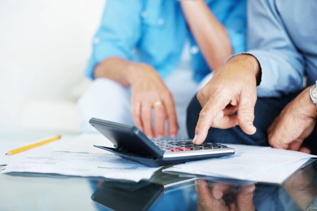 man and woman calculating finances on a calculator