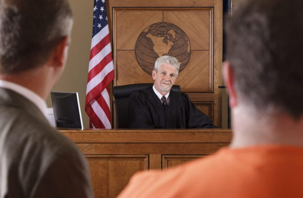 defendant and his lawyer speaking to the judge in a court room