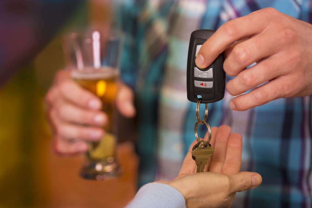 person who is drinking handing his keys to a designated driver
