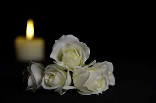 A candle and roses for a wrongful death memorial.
