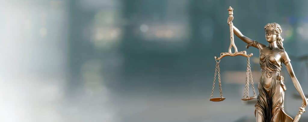 A Lady Justice statue sitting on a catastrophic injury lawyer's desk.