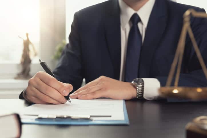 A wrongful death attorney working on paperwork at his desk. 